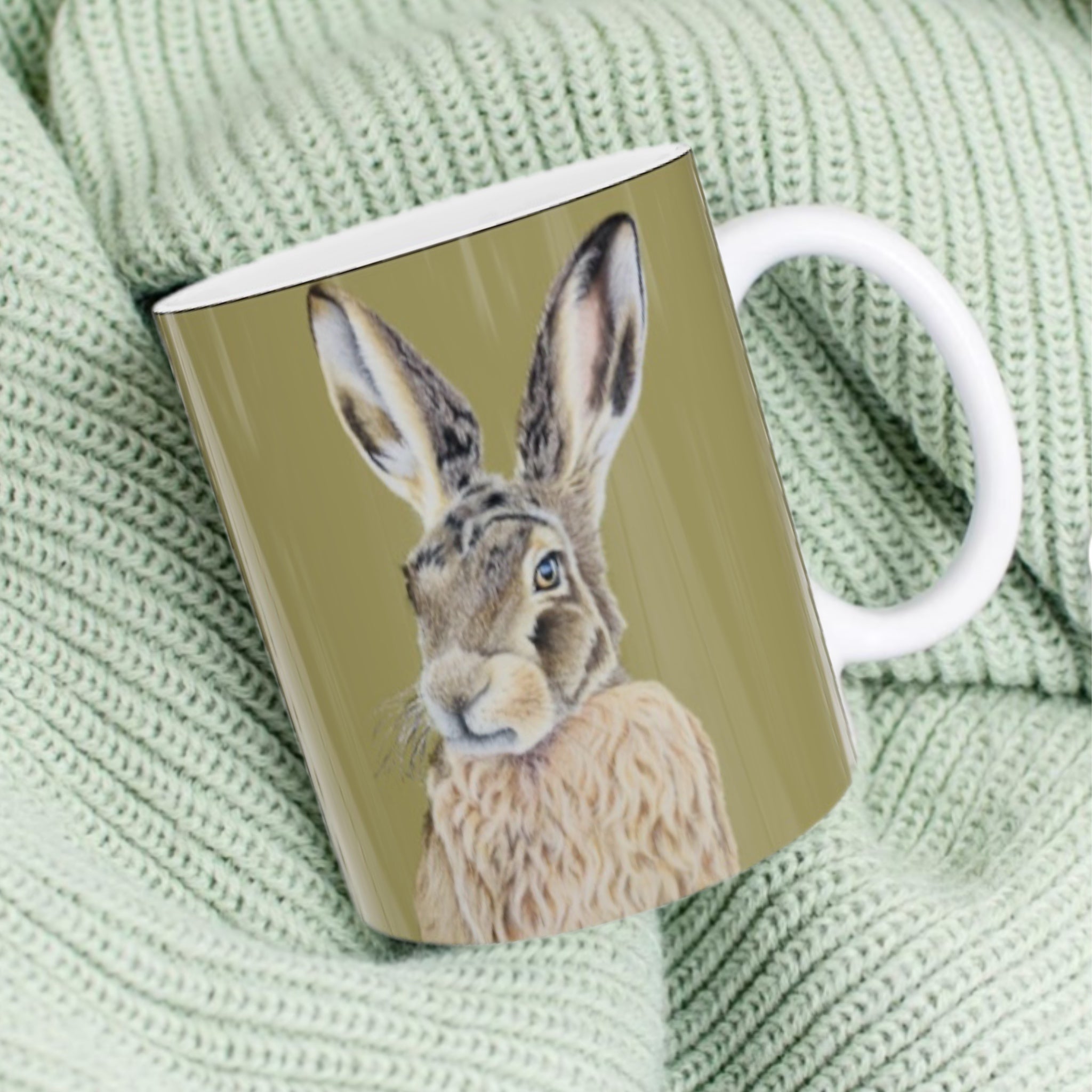 11oz ceramic mug with hare illustration against sage green background