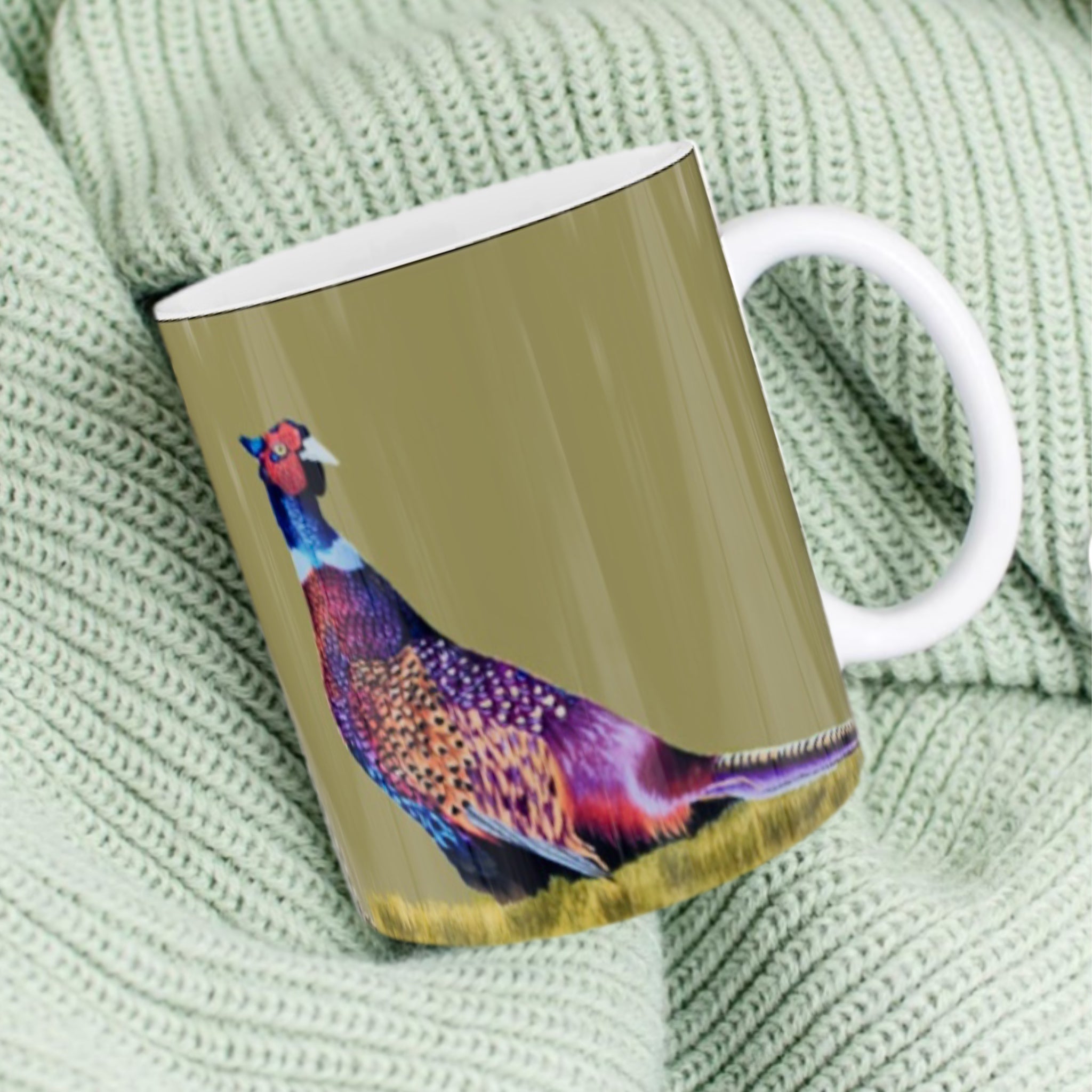 11oz ceramic mug with colourful pheasant illustration against sage green background