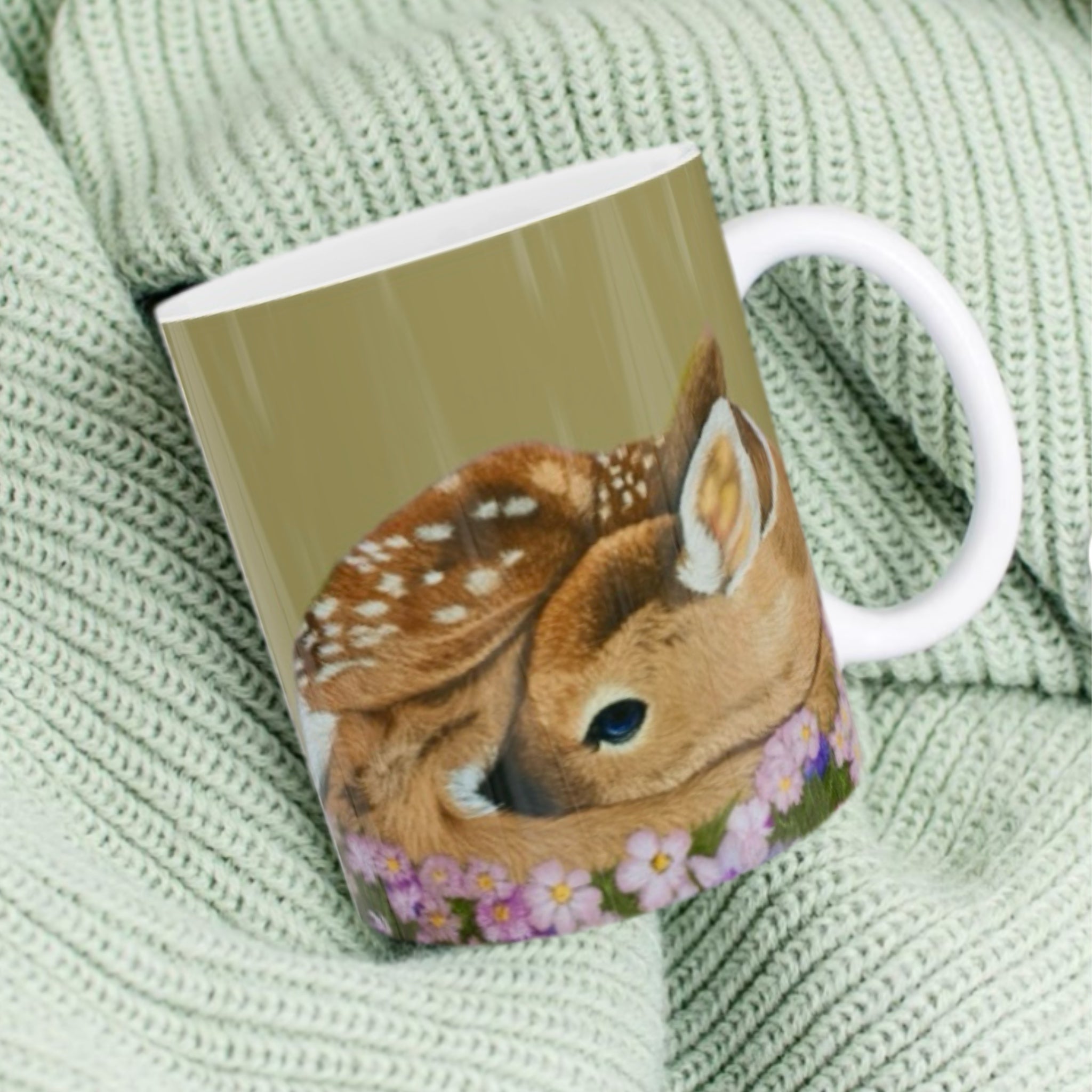 11oz ceramic mug with sleeping fawn in purple wildflowers illustration against sage green background
