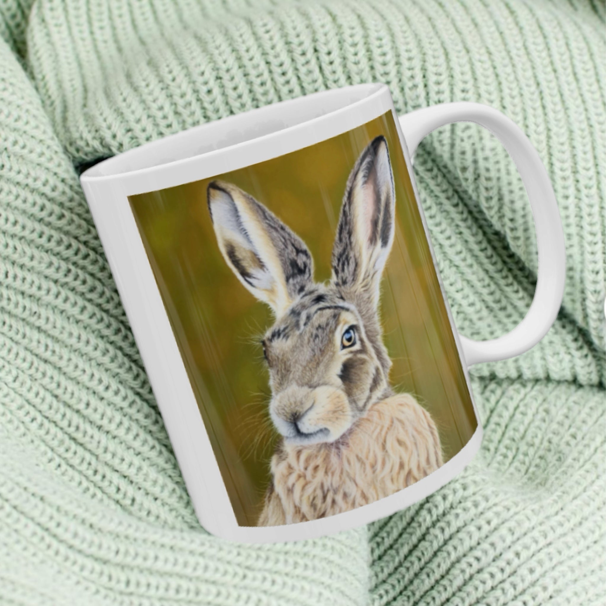 11oz ceramic mug with hare illustration against green woodland background
