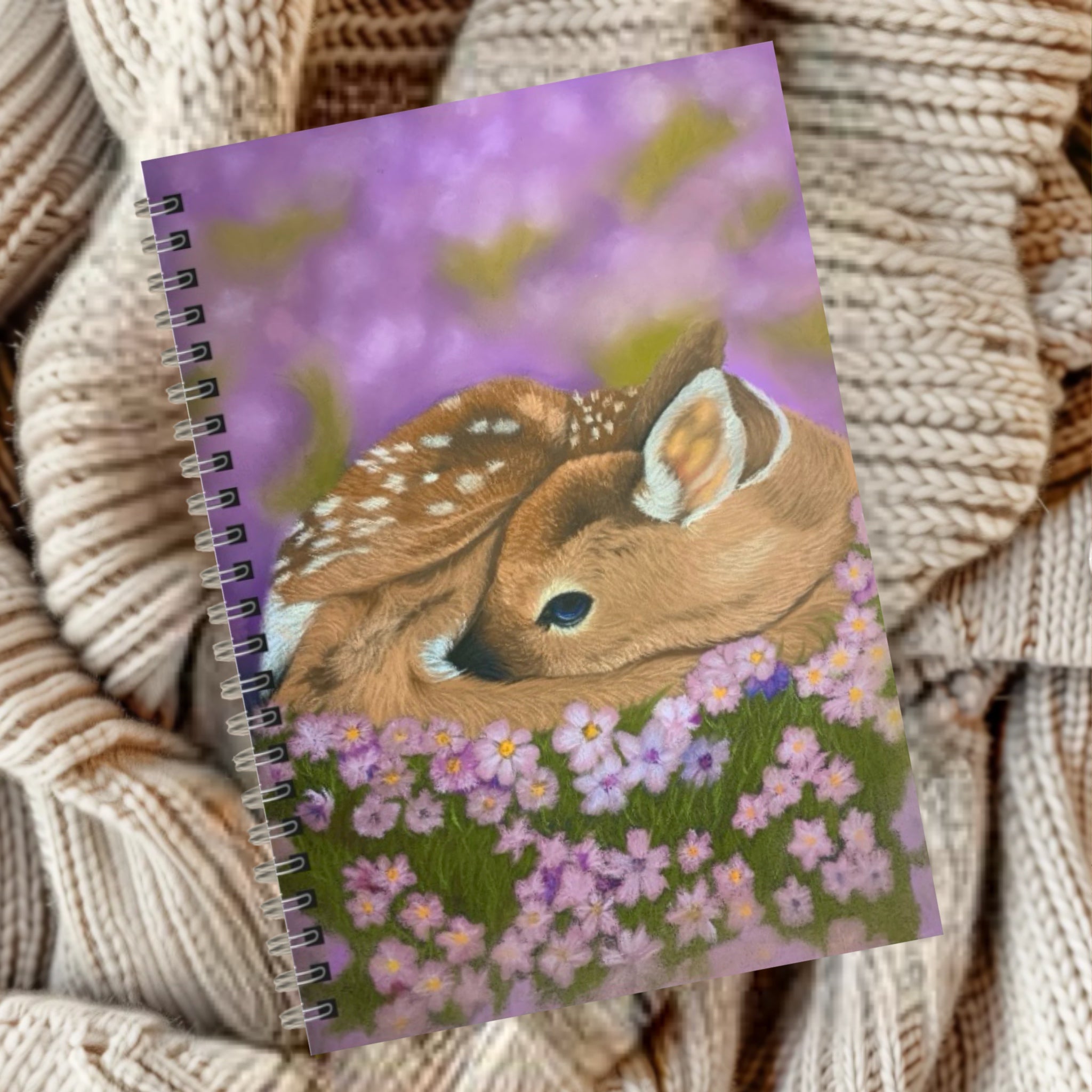 Notebook with a sleeping baby deer surrounded by purple wildflowers