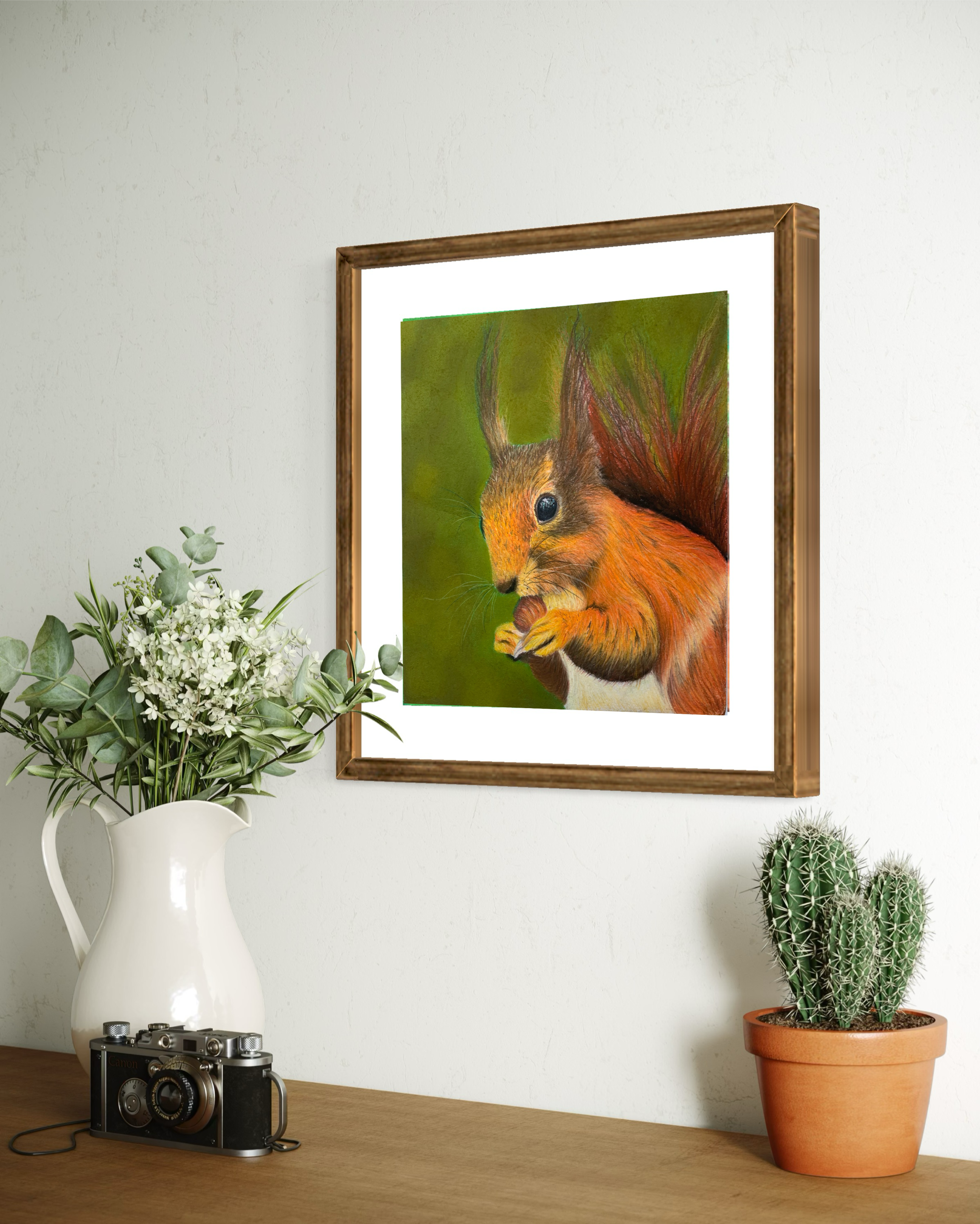 Framed art print of a red squirrel eating a nut against a green woodland inspired background