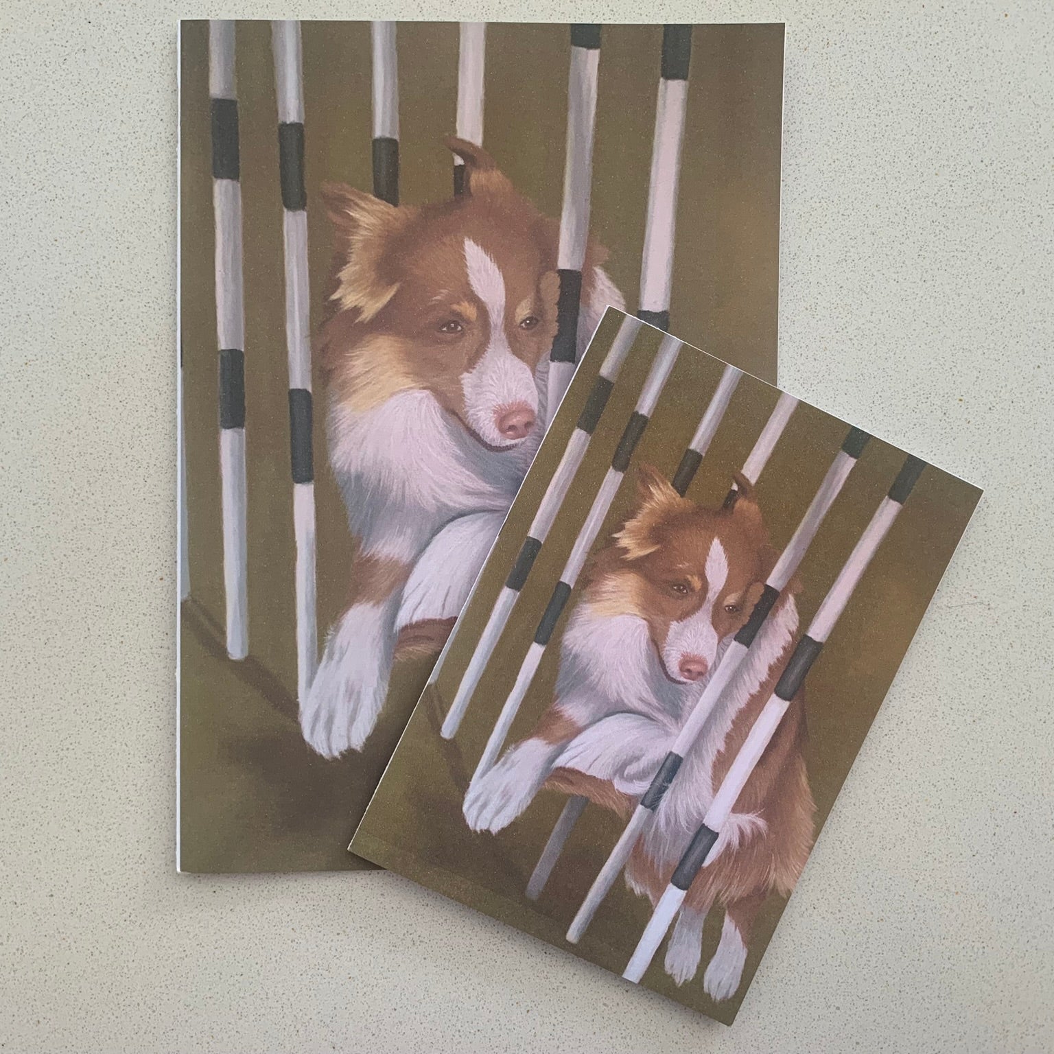 Two greeting cards with a dog design featuring a brown and white border collie weaving between poles on a green background.